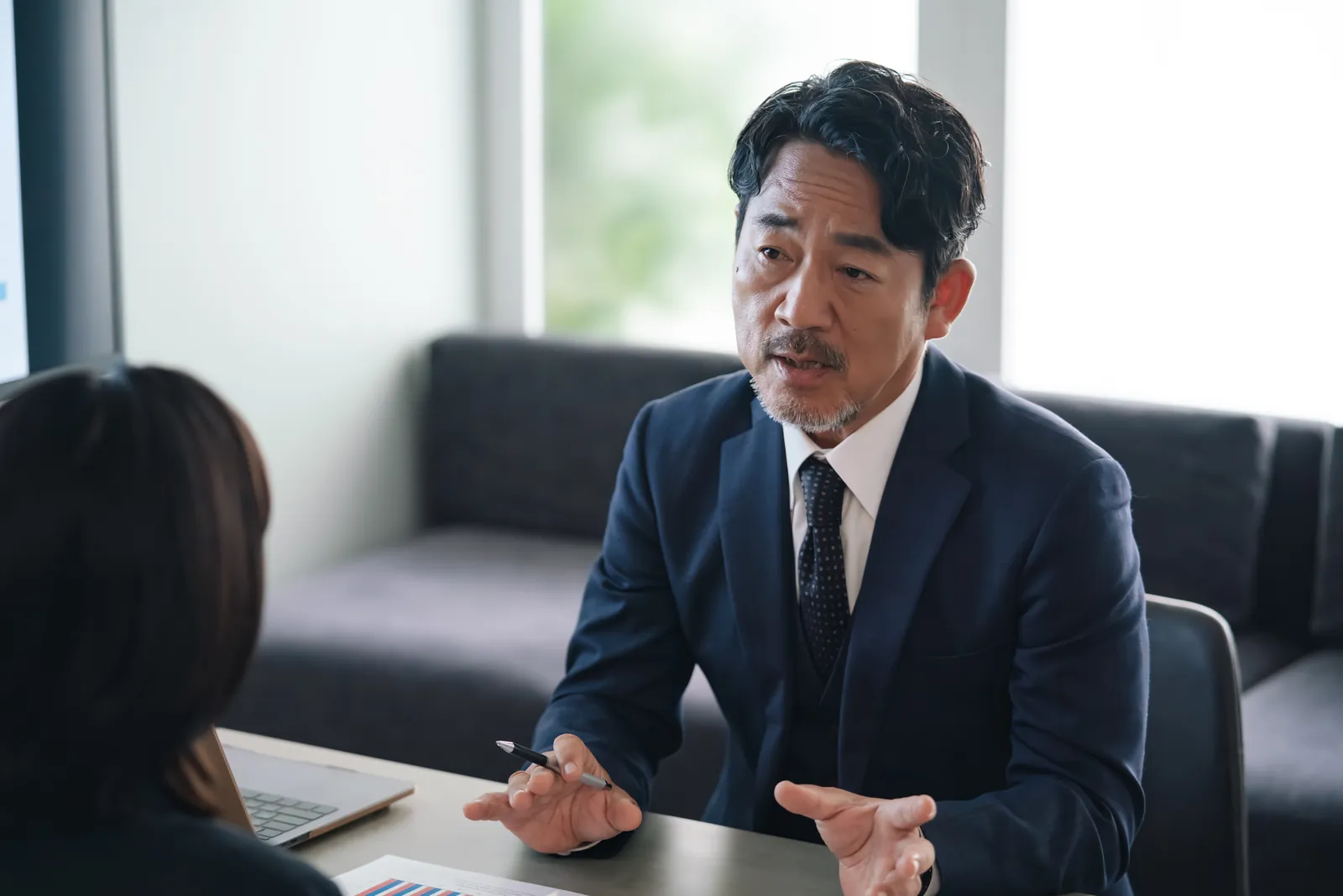 机をはさんで話す面接の場面