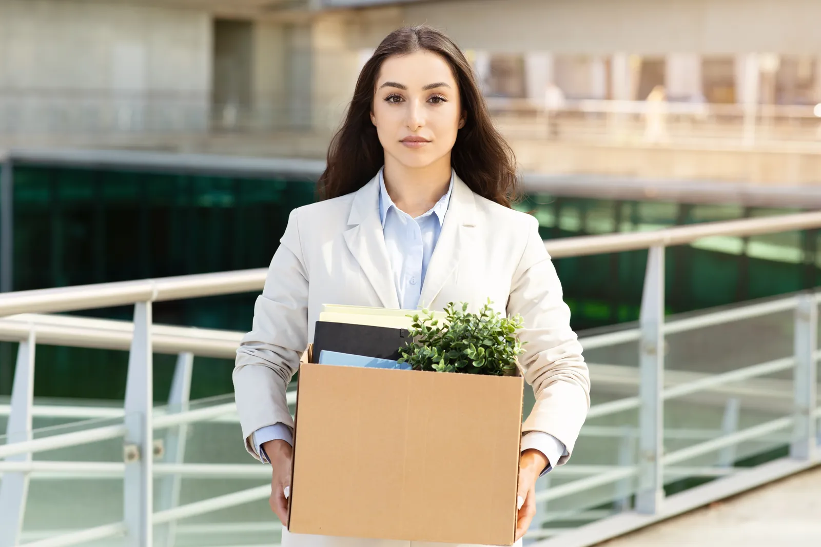 荷物の箱を抱えて職場を移る女性