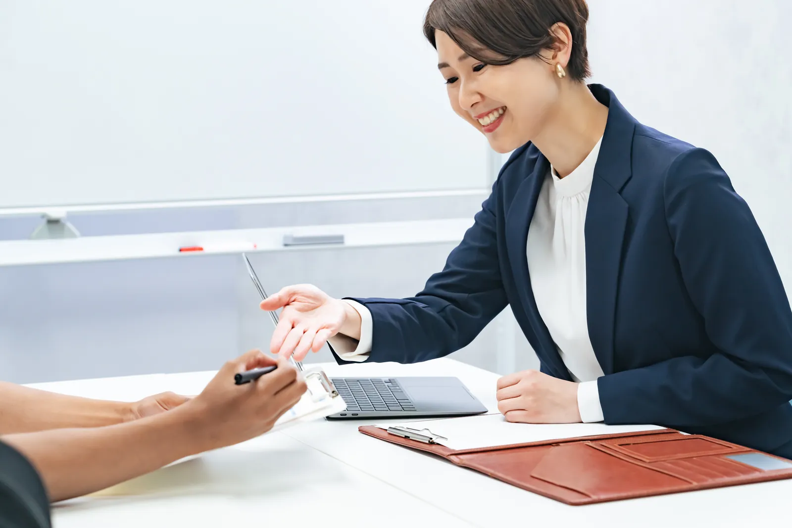 窓口で書類を前に、職員が来訪者に説明している